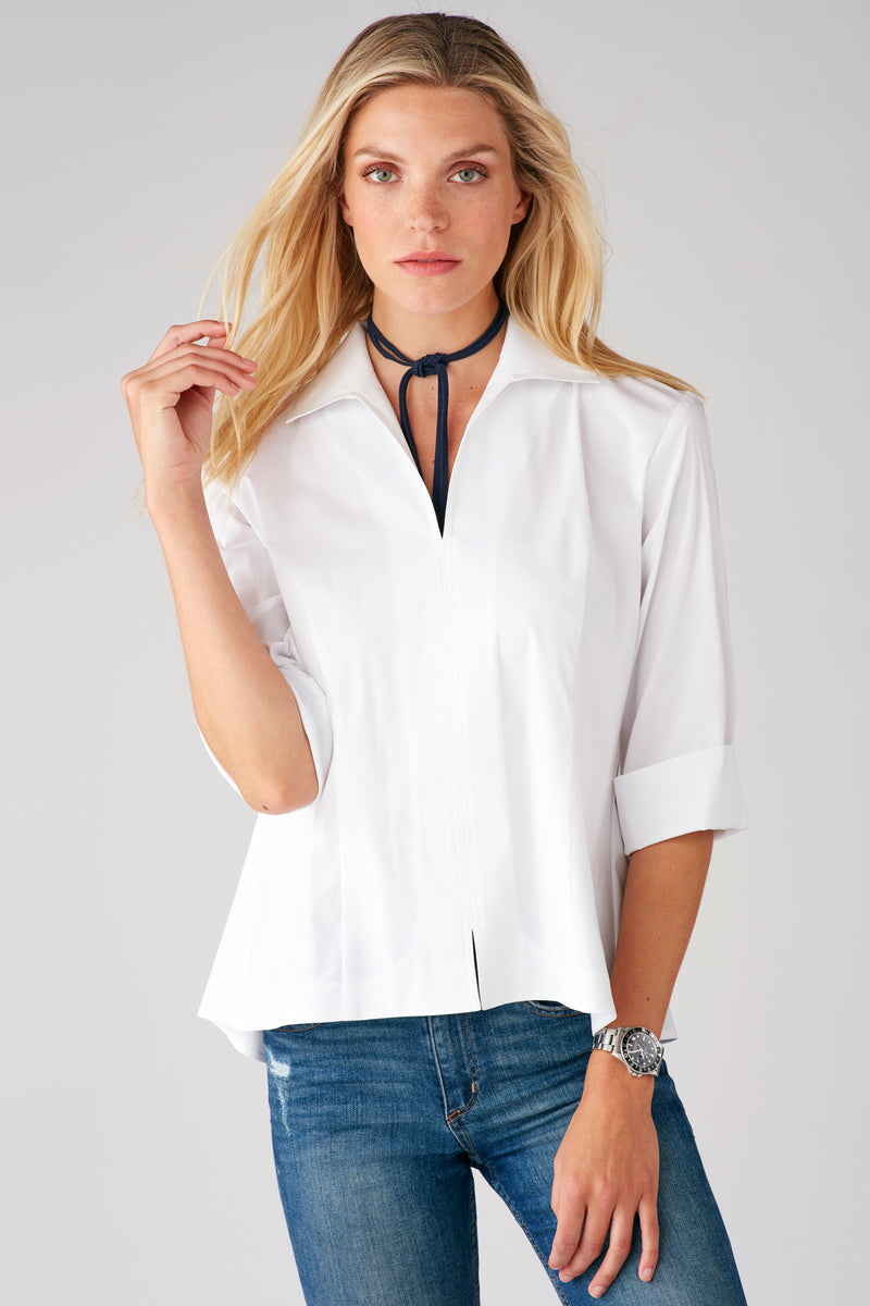 A blonde fashion model wearing the Finley Swing Shirt, a white 3/4 sleeve blouse with a turnback collar.