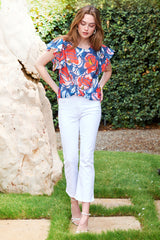 The Finley Rosie blouse, a cotton voile front-tie pullover blouse with short flutter sleeves and a red and blue floral print.
