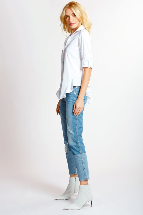 A model wearing the Finley Agetha shirt, a black button-down blouse with tabbed sleeves, a flounced hem, and a tailored fit.