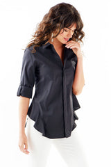 A model wearing the Finley Agetha shirt, a black button-down blouse with tabbed sleeves, a flounced hem, and a tailored fit.