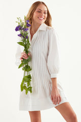 A model wearing the Finley Belinda dress, a tucked shirt dress with bracelet sleeves, a spread collar, and a rose red color.