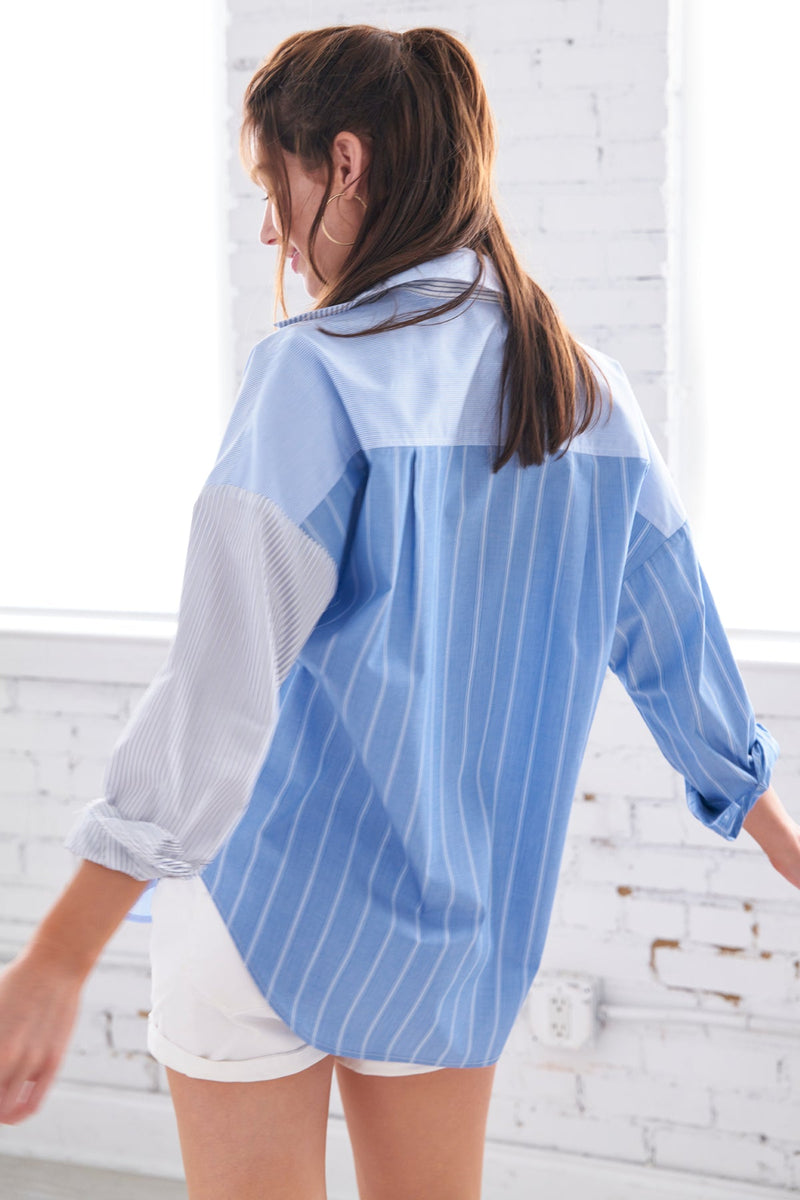 A model wearing the Finley boyfriend shirt, a color-blocked blue and white striped shirt with an asymmetric pocket.