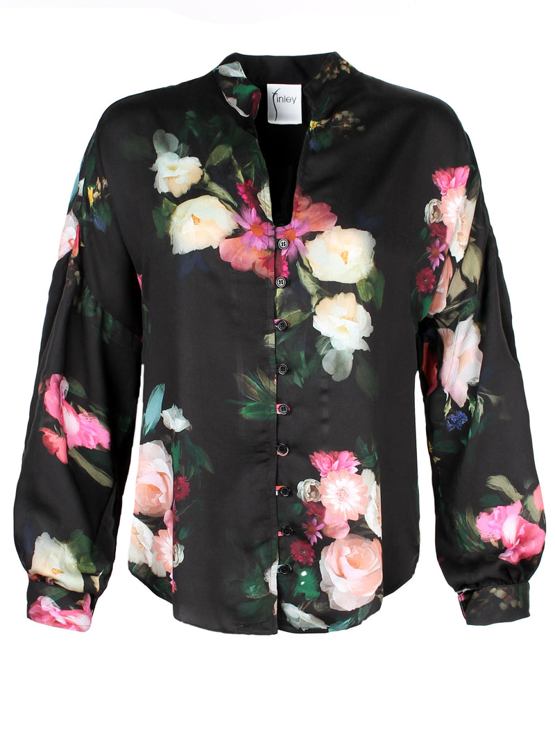 A front view of the Finley band collar blouse, a button down long sleeve shirt with a drop shoulder and a Dutch floral print.