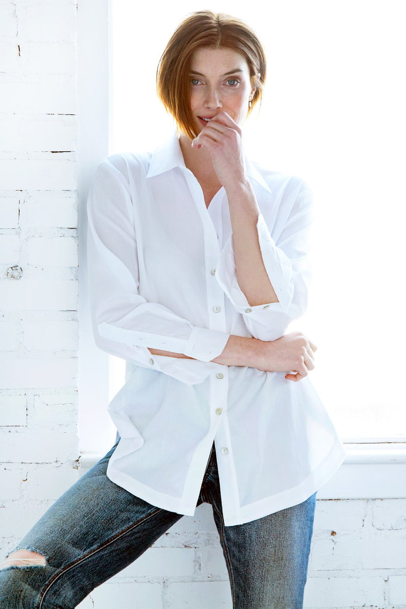 A fashion model wearing the Finley boyfriend shirt, a white cotton voile button-down blouse with a relaxed fit.