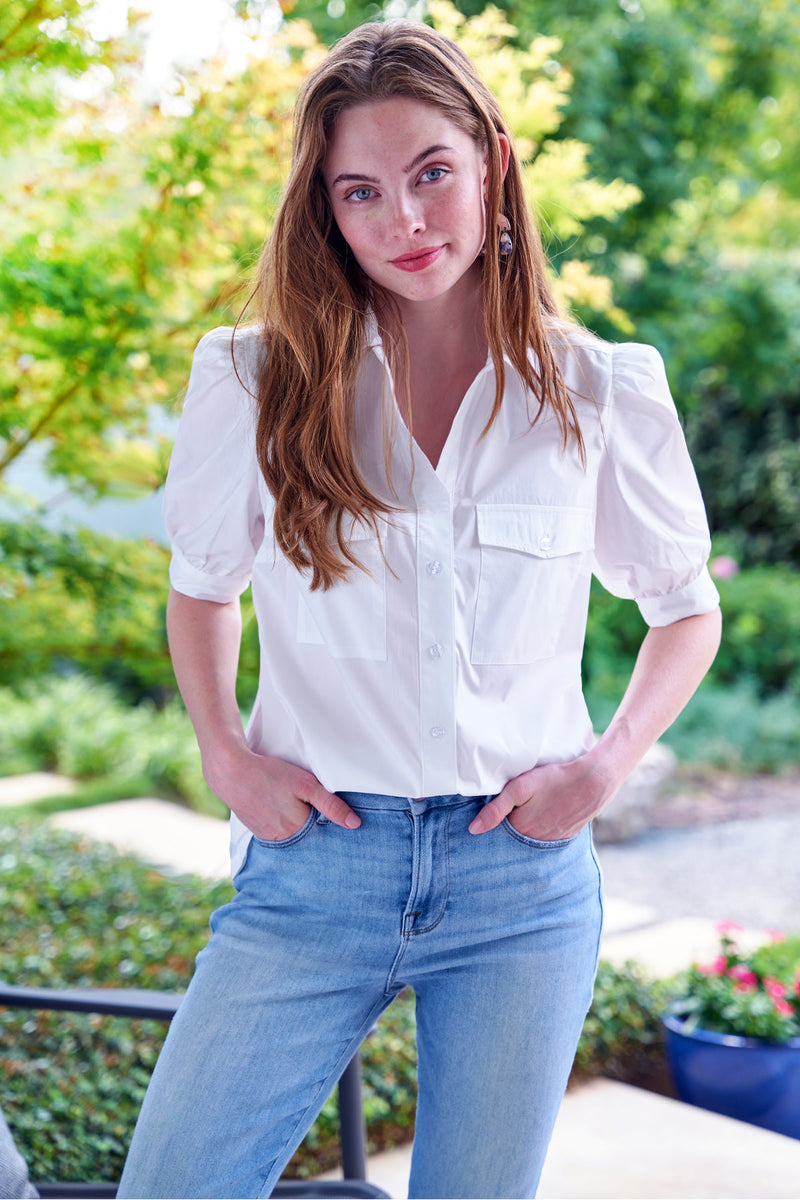 The Finley camp shirt, a white button down weathercloth blouse with chest pockets, short puff sleeves, and a relaxed fit.