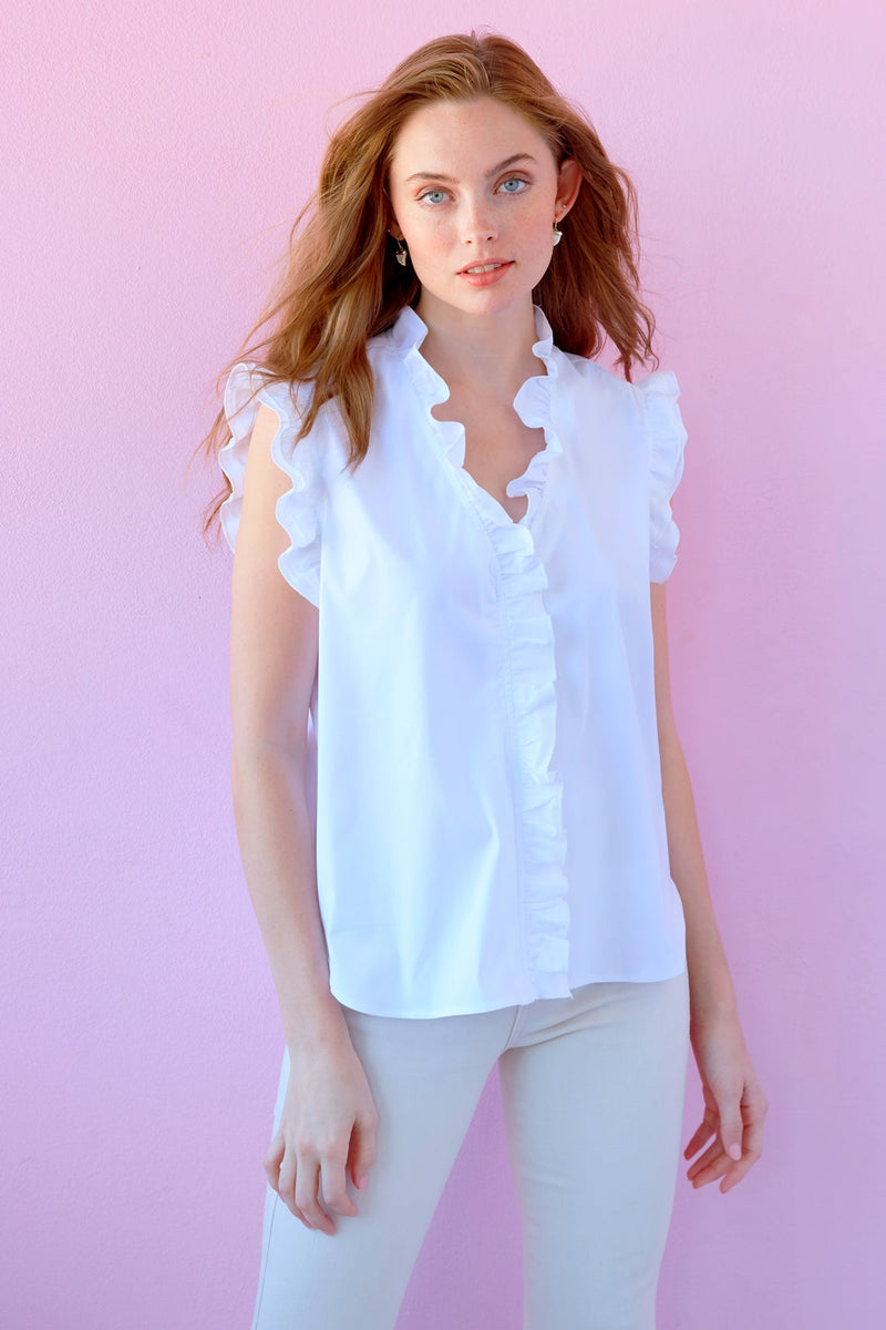 A model wearing the Finley Byrdee blouse, a casual  sleeveless white button-down blouse with ruffle collar and sleeve detail.
