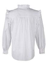 A front view of the Finley Byrdee blouse, a long sleeve white poplin top with ruffled trim, tonal piping, and a v neckline.