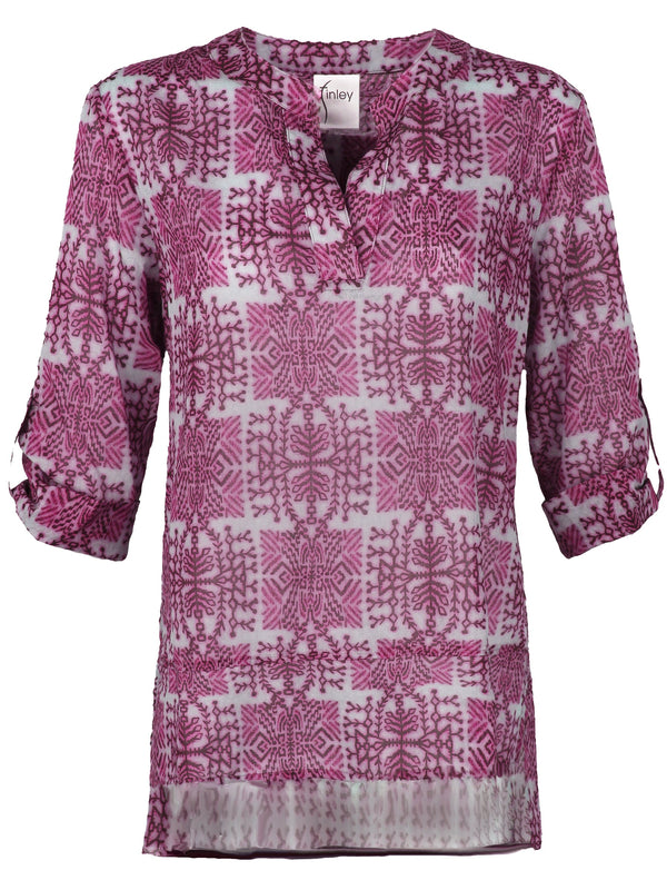 A model wearing the Finley Carley blouse, a cotton voile tunic with epaulettes, a relaxed fit, and a pink tribal print.