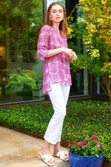 A model wearing the Finley Carley blouse, a cotton voile tunic with epaulettes, a relaxed fit, and a pink tribal print.