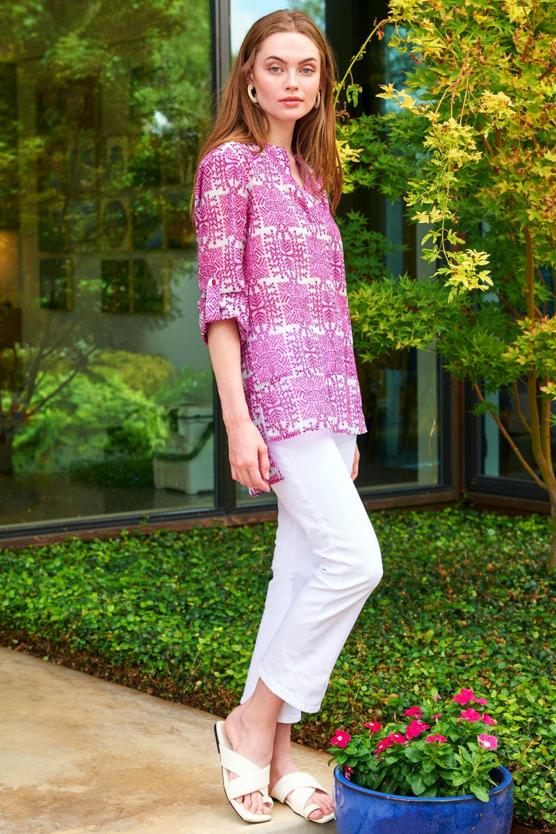 A model wearing the Finley Carley blouse, a cotton voile tunic with epaulettes, a relaxed fit, and a pink tribal print.