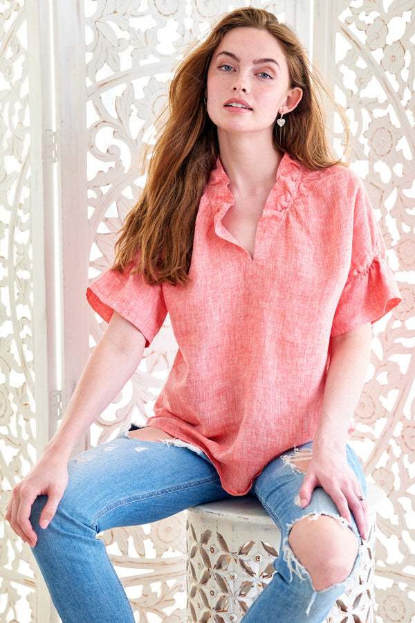 The Finley Crosby blouse, a peach pink short-sleeve casual washed linen blouse with a ruffle collar and relaxed fit.
