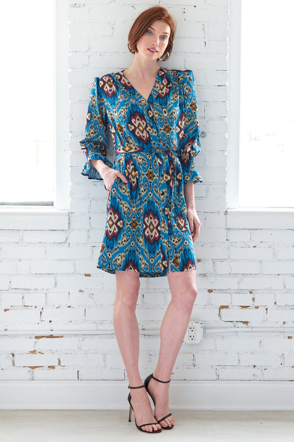 A model wearing the Finley Helena dress, a slipover midi shirt dress with 3/4 sleeves and an abstract teal blue print.