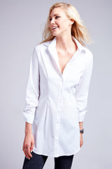 A blonde model wearing the Joey poplin, a white button-down blouse with a tailored fit and tabbed sleeves.