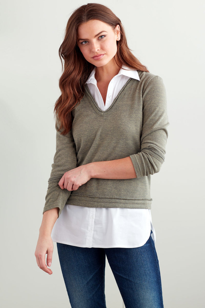 A fashion model wearing the Finley layering tank, a white sleeveless button-down blouse with a shirt-tail hem.