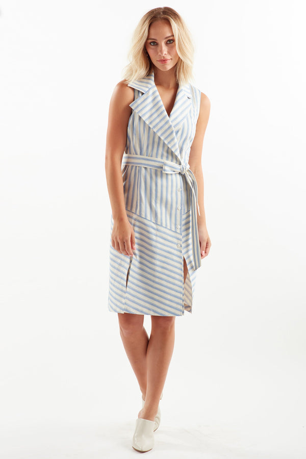 A blonde fashion model wearing the Finley Marni dress, a sleeveless double-breasted dress with a blue stripe pattern and a tie front..