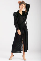 A model wearing the Finley Mary Jane Whisper dress, a navy velvet dress with ruffle detailing and a semi-fitted shape.