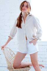 A fashion model wearing the Finley Monica blouse, a washed linen button-down shirt with a relaxed fit and a natural gray color.