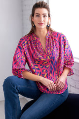 The Finley Rex blouse, a popover puff sleeve cotton shirt with a relaxed shape and a pink and purple cheetah print.