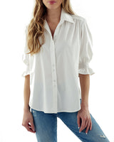 A fashion model wearing the Finley Sirena blouse, a white button-down poplin shirt with puffed sleeves and a relaxed fit.