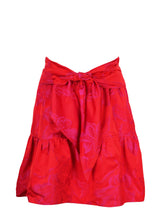 The Finley tiered skirt, a front tie midi skirt with an elastic waistband, flouce ruffle hem, and a red floral Jacquard pattern.
