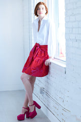 The Finley tiered skirt, a front tie midi skirt with an elastic waistband, flouce ruffle hem, and a red floral Jacquard pattern.