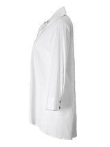 A profile view of the Finley trapeze top, a white button-down tunic blouse with an A-line shape and a relaxed fit.